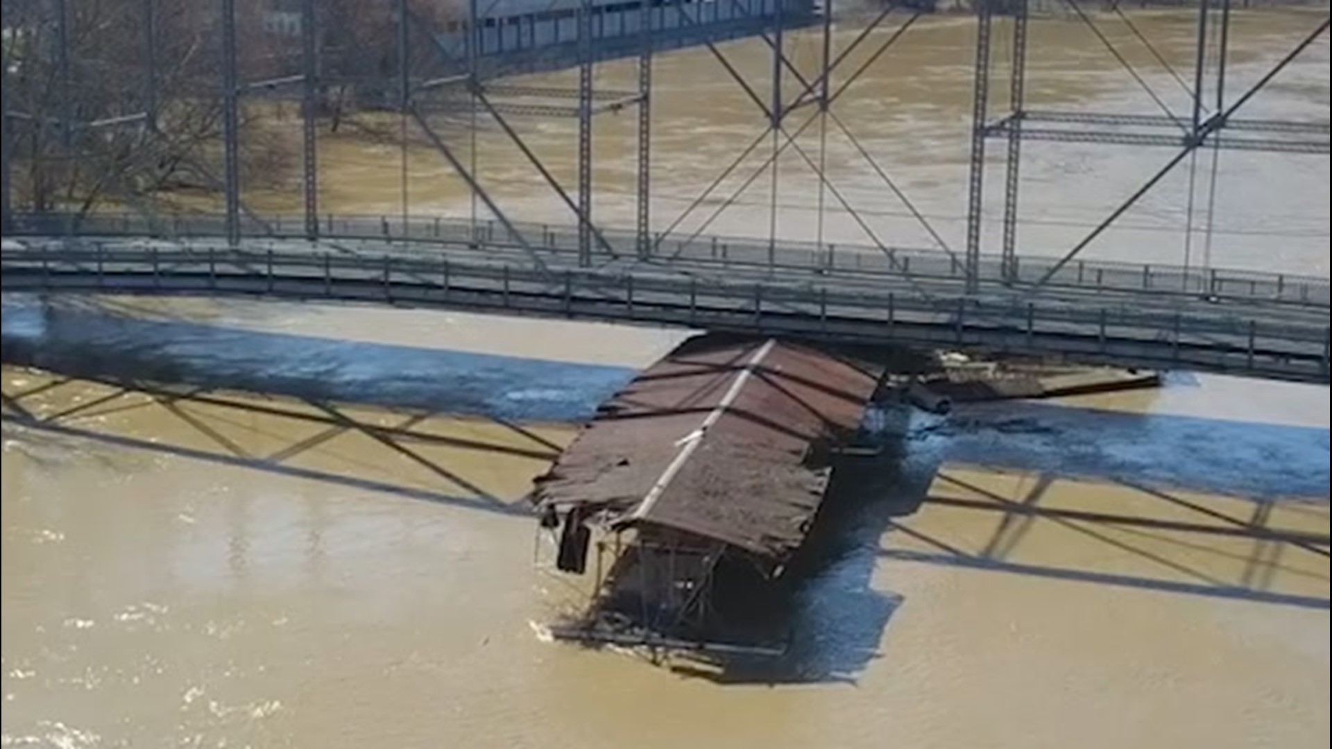 Drone footage shows a 200-foot-long marina, which broke loose amid heavy flooding, ramming into the Singing Bridge in Frankfort, Kentucky, on March 3.