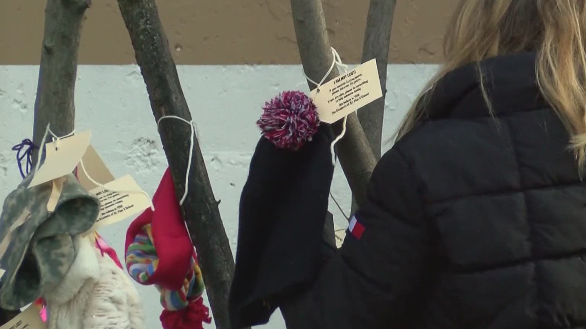 The students put hats and scarves on trees and benches for anyone who needs them.