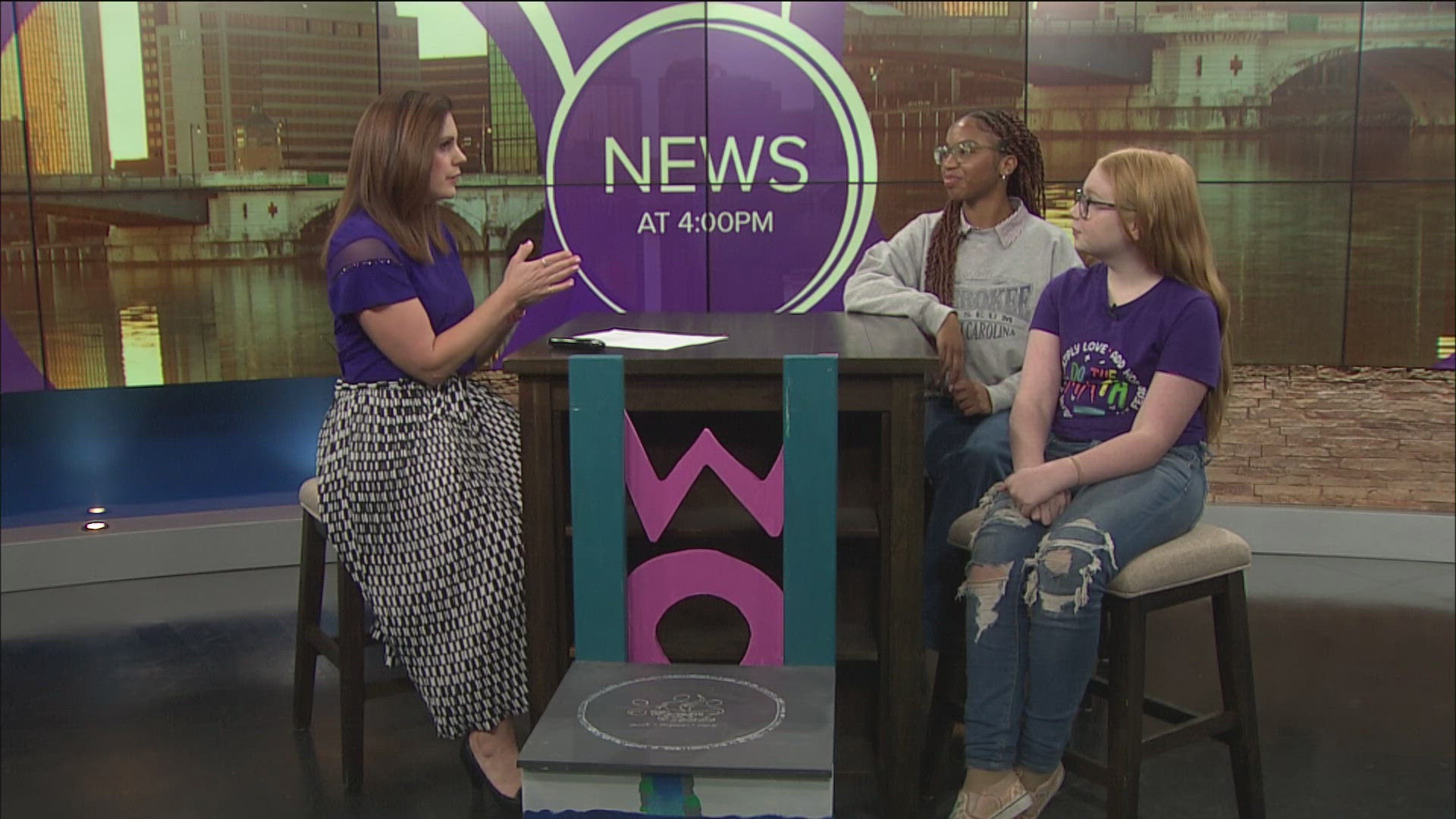 Stormy Hogle with Women of Toledo's Youth Initiative Board and Lucy Harbick, an International Day of the Girl Panel moderator, talk about the event.