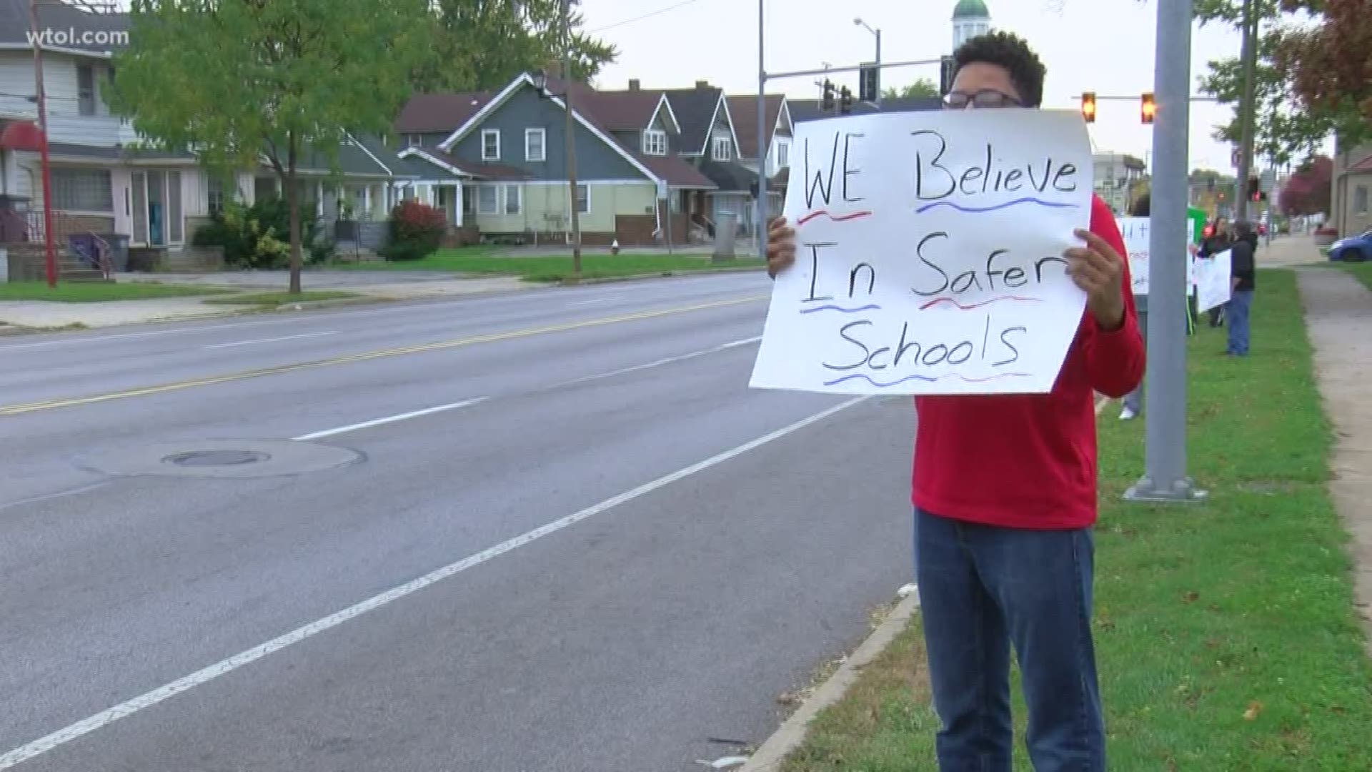 A dozen neighbors stood along Sylvania Avenue with signs hoping to bring change and create safer schools.