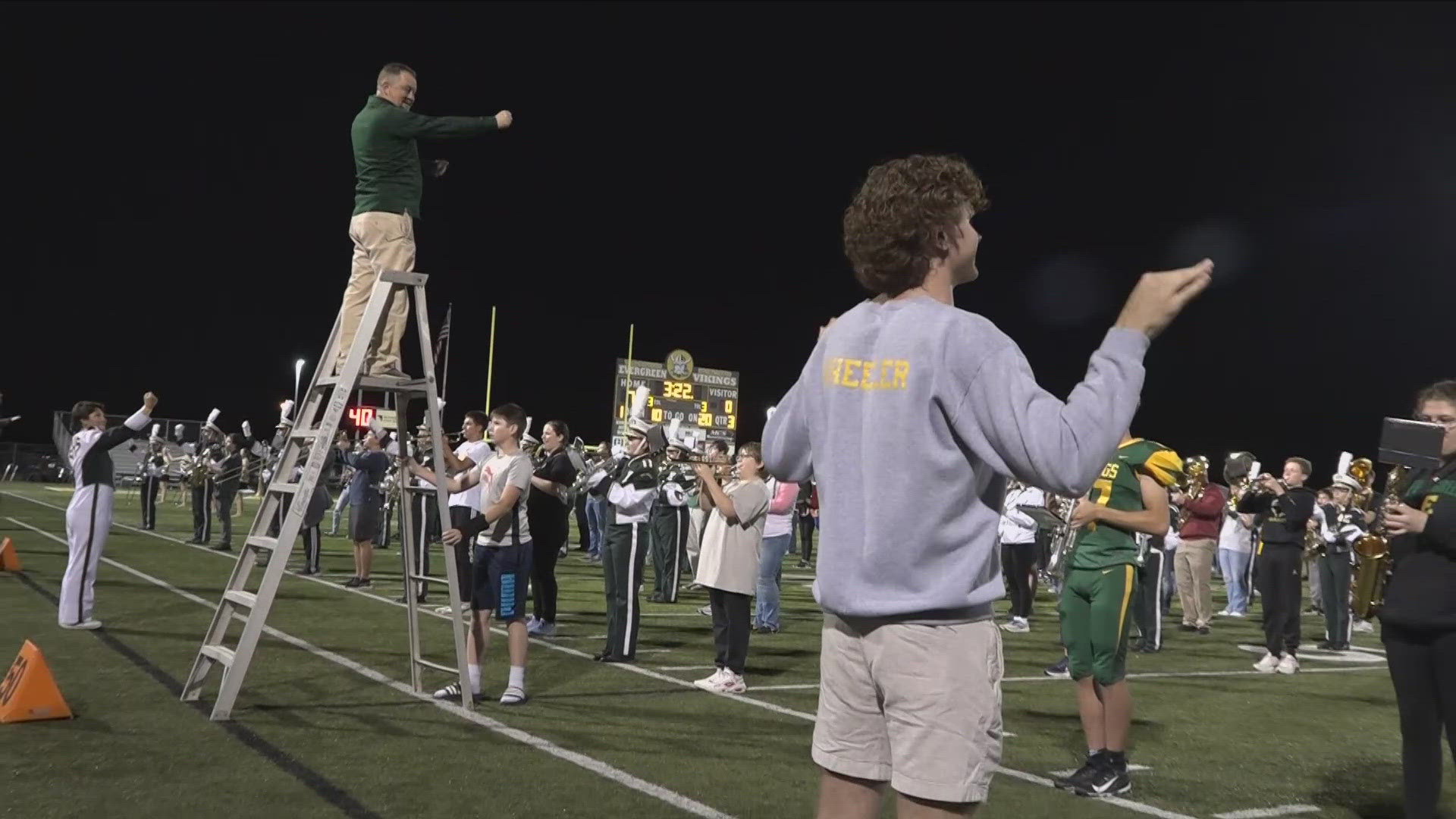 More than 100 band alumni joined the school's current band on the field during Friday's homecoming game to celebrate the career of Chris Lyons.