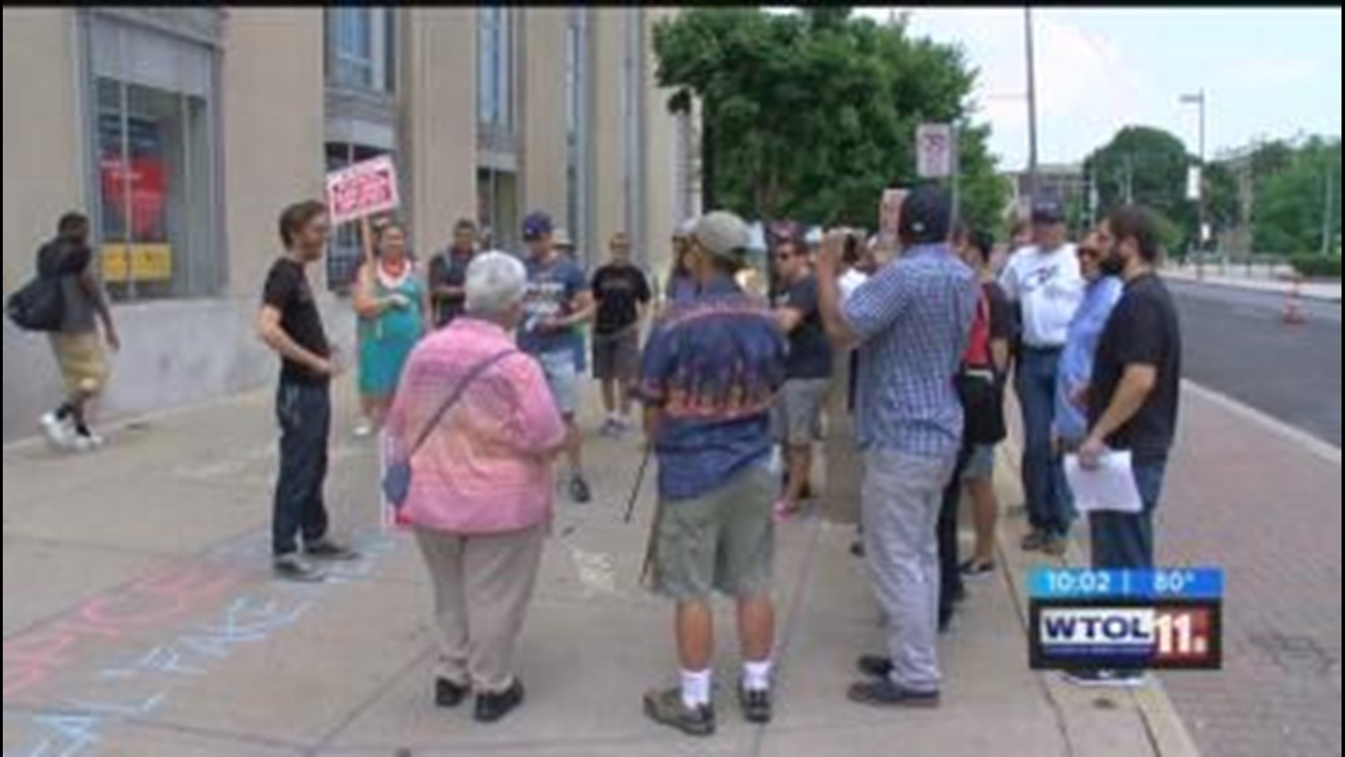 Former WH Press Secretary greeted by protesters at Toledo Library appearance