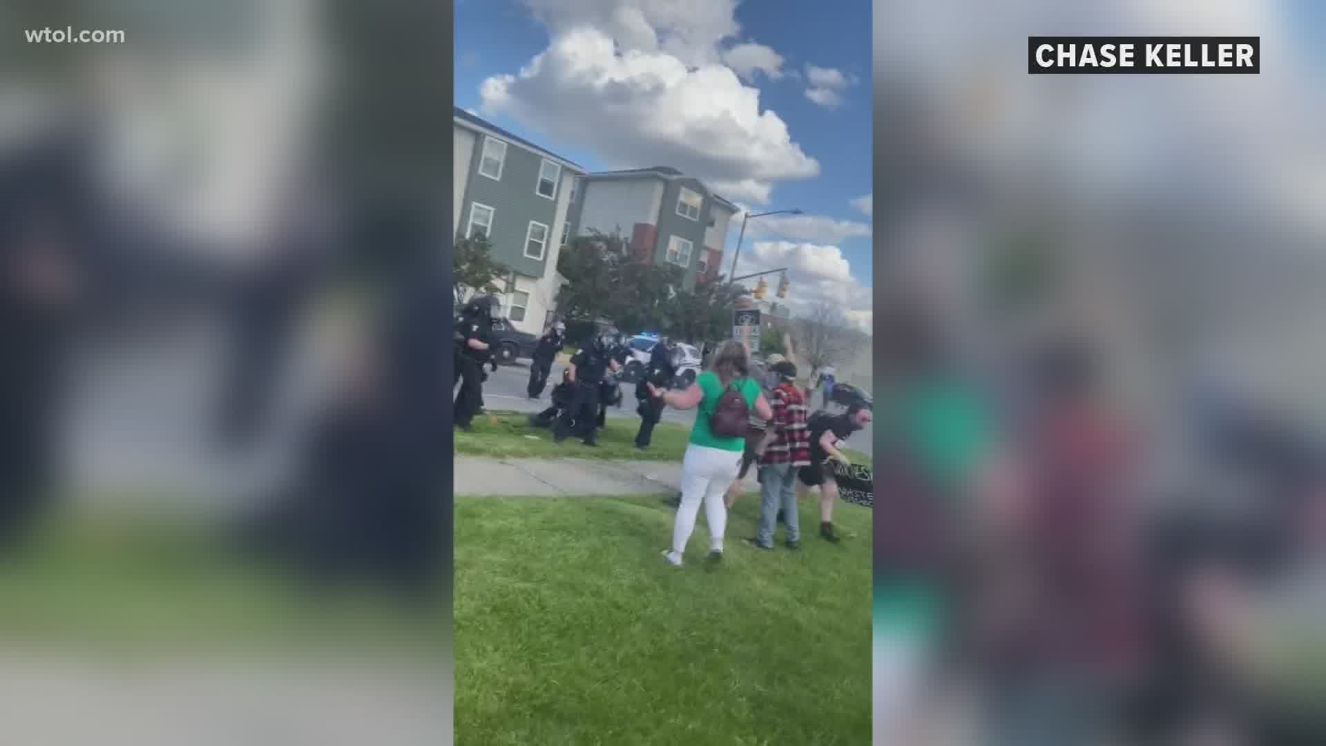 A city of Toledo spokesperson confirmed one of the officers was seen swinging his helmet and "seemingly striking" a protester.