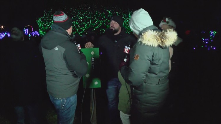 Army veteran Stephen Flory and his family light the big Christmas tree at the Lights Before Christmas at the Toledo Zoo