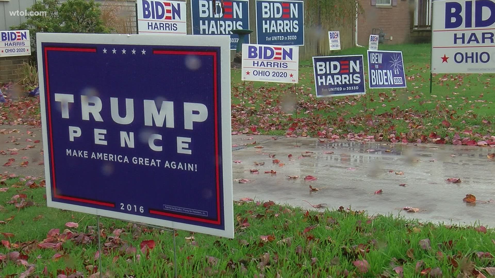 Two homes near the Lime City Road-Dixie Highway roundabout are decked out in opposing political signage, but the residents are the closest of friends.