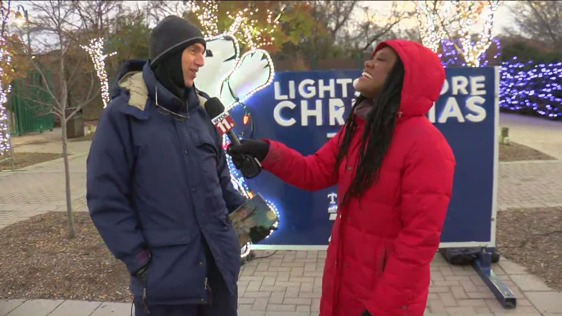 Director Tim Cloeter talks with TaTiana Cash about getting ready to perform at the kickoff for Lights Before Christmas at the Toledo Zoo Friday.