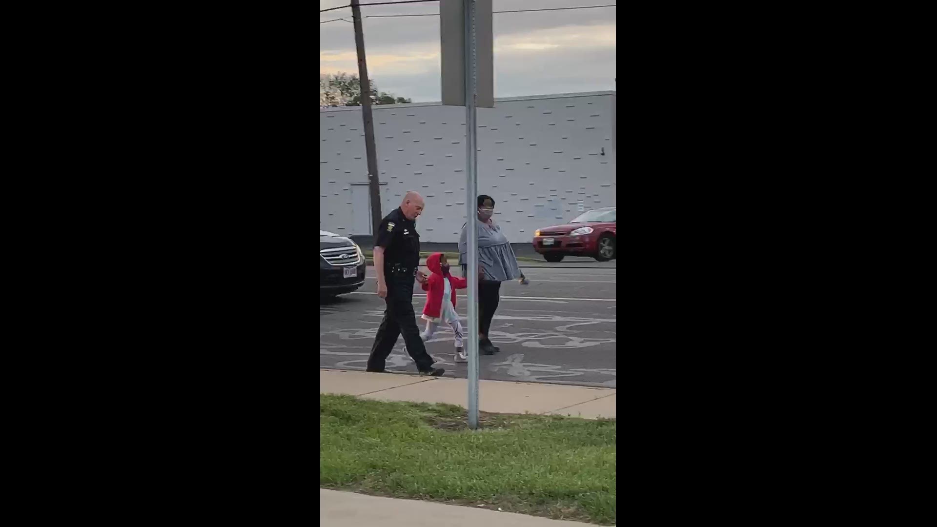 Officer walks hand-in-hand with child.