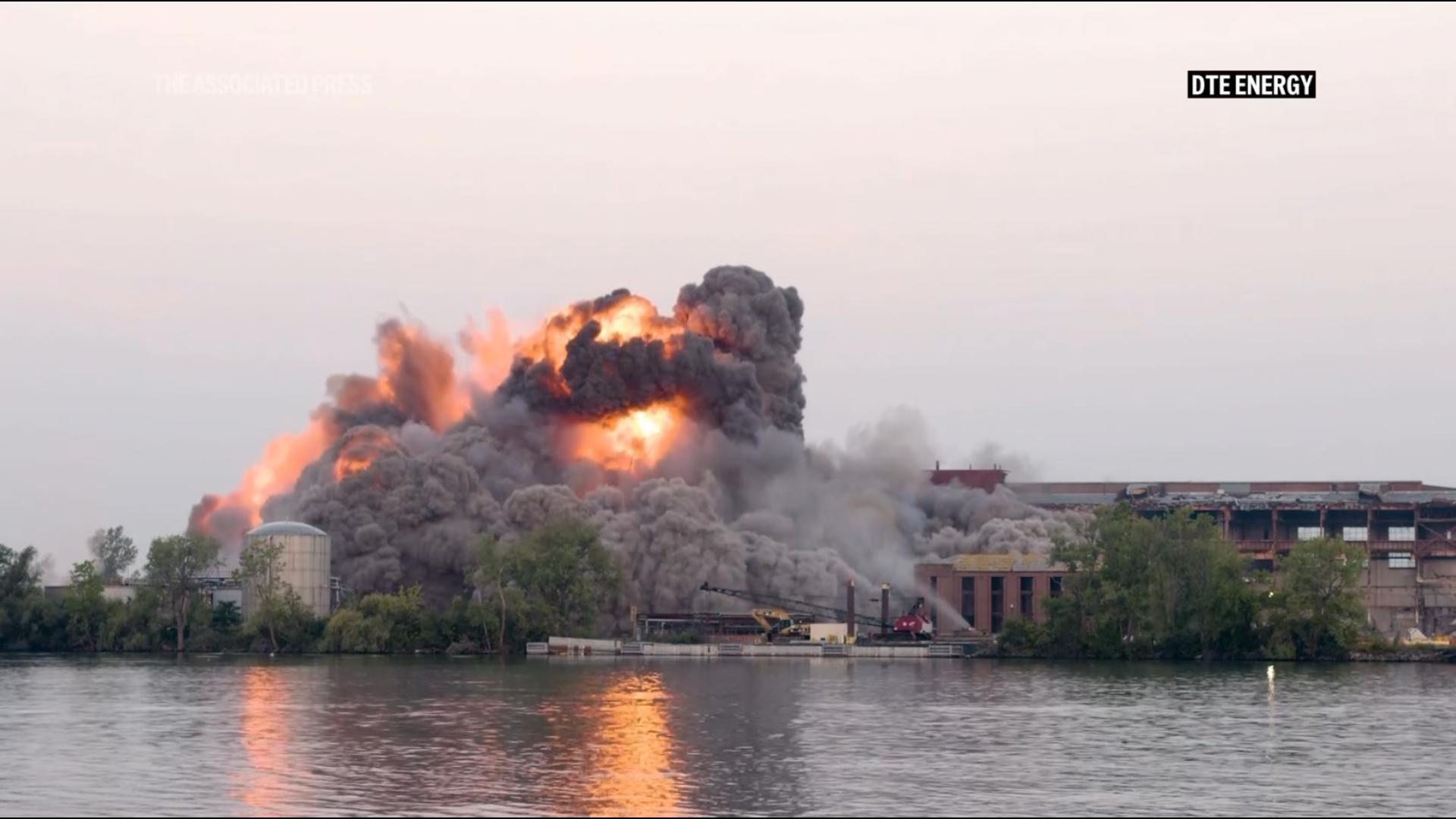 Part of a shuttered power plant near Detroit was demolished Friday by explosives that turned the structure into piles of rubble and kicked up dust and flames.