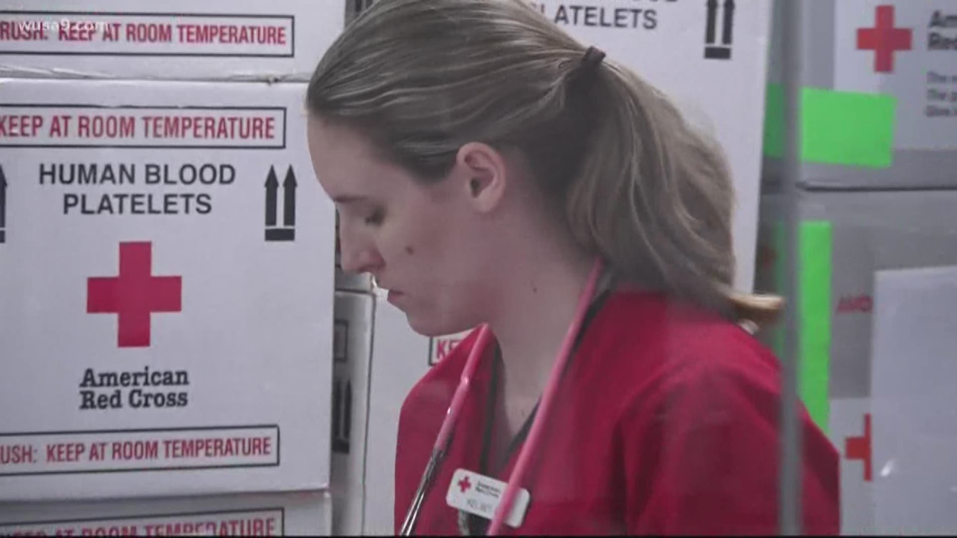 Medics take the temperatures of all blood donors before anyone is approved to enter a Red Cross blood drive, with social distancing in place.